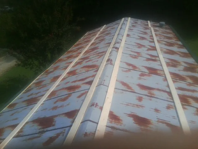 Rusted metal roof panels with new wood purlins before replacement — Storm Damage Roof Repair in Larimer by Roofing Brothers